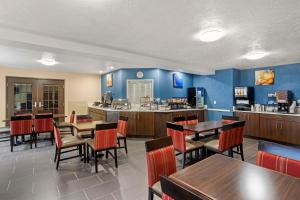 a restaurant with tables and chairs and a kitchen at Comfort Inn in Huntingdon