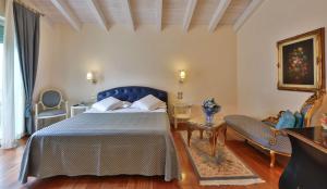 a bedroom with a blue bed and a couch at Hotel Globus, Sure Hotel Collection by Best Western in Milano Marittima