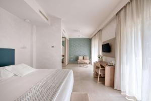 a bedroom with a bed and a desk and a chair at Hotel Globus, Sure Hotel Collection by Best Western in Milano Marittima