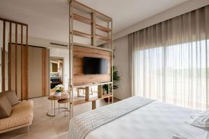 a bedroom with a bed and a tv on a shelf at Hotel Globus, Sure Hotel Collection by Best Western in Milano Marittima