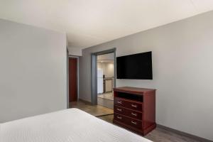 um quarto com uma cama e uma televisão de ecrã plano em Clarion Inn and Suites Airport em Grand Rapids