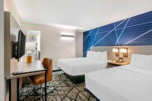 a hotel room with two beds and a desk at Comfort Inn in Kansas City