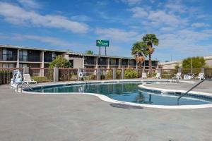 a swimming pool in front of a hotel with a building at Suburban Studios in Rock Hill