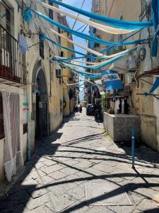 un vicolo con ombrelli blu appesi su una strada di Casa Paradiso a Napoli