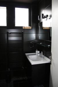 a black bathroom with a sink and a window at Superbe T4 à Royan, 2 minutes à pied de la mer. in Royan