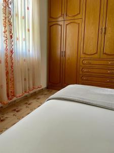 1 dormitorio con 1 cama y armario de madera en Cortina House Berat en Stalin