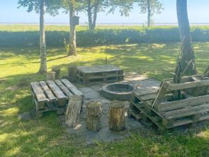 Helberskovにある5 person holiday home in Hadsundの火炉と畑の木製のベンチ2つ