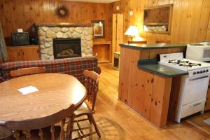 cocina y sala de estar con mesa y fogones en Holiday Acres Resort, en Rhinelander