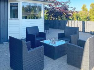 een patio met stoelen, een tafel en een hek bij 7 person holiday home in Hadsund in Hadsund