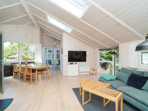 Una sala de estar con un sofá azul y una mesa. en 7 person holiday home in Græsted-By Traum, en Græsted