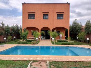 een gebouw met een zwembad voor een gebouw bij Villa ourika Marrakech in Ourika