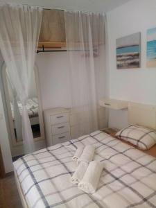 een slaapkamer met een bed met 2 witte kussens bij Most sunny days on Gran Canaria in Puerto Rico de Gran Canaria