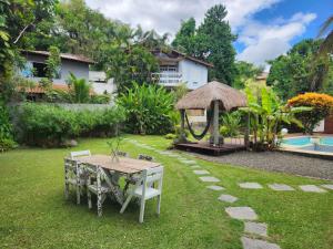 a garden with a table and a gazebo at Casa Bali 1 2 3 in Niterói