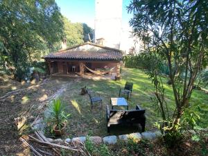 una pequeña casa con una mesa y sillas en un patio en Casa junto al bosque, en Bescanó