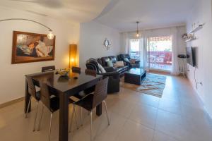 a dining room and living room with a table and chairs at Apartamento Punta del Faro in Torrox Costa