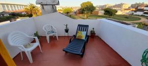 a balcony with two chairs and a table and chairs at Casa Amarela in Esmoriz