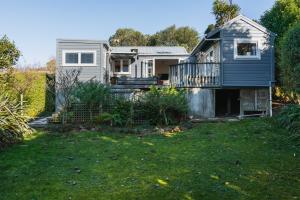 een klein huis met een balkon en een tuin bij Cottage on Aotea in Dunedin