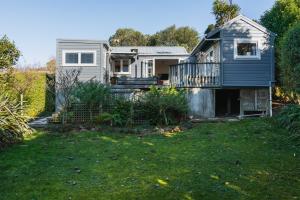 a small house with a balcony and a yard at Cottage on Aotea in Dunedin