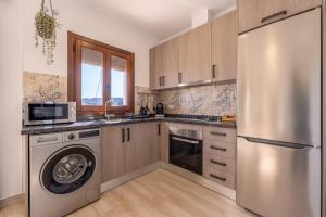 uma cozinha com uma máquina de lavar roupa e um frigorífico de aço inoxidável em Apartamento Chic em Frigiliana