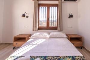 um quarto com uma cama grande e uma janela em Apartamento Chic em Frigiliana
