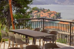 una mesa y sillas en un balcón con vistas en Vertmont Apartments, en Sveti Stefan