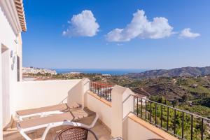 a balcony with chairs and a view of the ocean at Apartamento Chic in Frigiliana