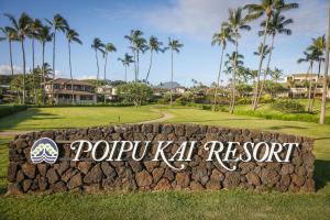 een bord voor een golfbaan met palmbomen bij Aston At Poipu Kai in Koloa