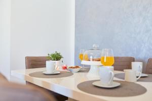 uma mesa com dois copos de sumo de laranja e uma batedeira em Villa Callista em Dubrovnik
