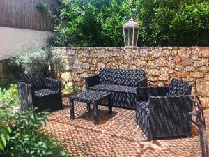 a patio with chairs and a table and a stone wall at Villa Mon Rêve in Le Cannet