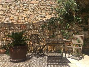 a table and two chairs in front of a stone wall at Villa Mon Rêve in Le Cannet