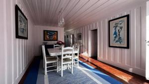 a dining room with a white table and chairs at Palheiro da Ana in Costa Nova