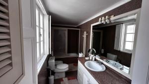 y baño con lavabo, aseo y espejo. en Palheiro da Ana en Costa Nova