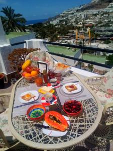 a table with food on it with a view of the ocean at Most sunny days on Gran Canaria in Puerto Rico de Gran Canaria