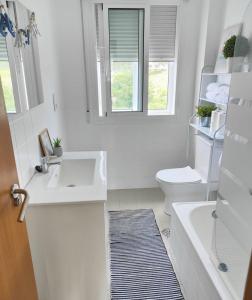 a white bathroom with a sink and a toilet at Lourido playa in Pontevedra