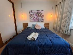 a bedroom with a blue bed with towels on it at Novíssimo APTO metrô na porta VLT Centro Rio in Rio de Janeiro +28 photos