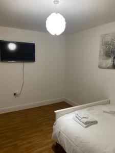 a bedroom with a bed and a tv on the wall at Streatham high street in London