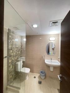 a bathroom with a toilet and a sink and a shower at سافانا امواج Amwaj savana in Half Moon Bay