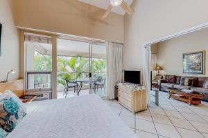 a bedroom with a bed and a living room at Maui Banyan B204 in Wailea