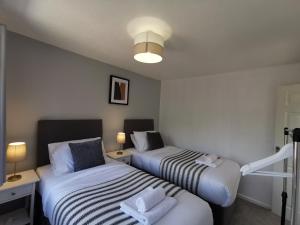 duas camas num pequeno quarto com duas lâmpadas em Dawley Detached House 3 Bedrooms with parking, garden, Wi-Fi em Dawley