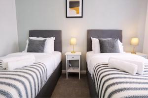 two beds sitting next to each other in a room at Dawley Detached House 3 Bedrooms with parking, garden, Wi-Fi in Dawley