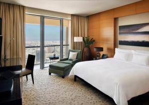 a hotel room with a large bed and a chair at Deluxe Studio Address Dubai Mall "The Residence" in Dubai