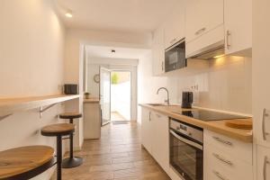 a kitchen with white cabinets and a wooden floor at Modern brand new Apartment Torrevieja Centre 2 in Torrevieja