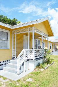 Casa amarilla con porche blanco y escaleras en Sunshine Cozy Cottage en Clearwater Beach