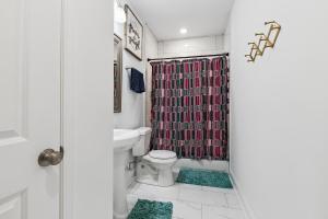 a bathroom with a toilet and a shower curtain at New Luxury 3BR w Jacuzzi in New Orleans