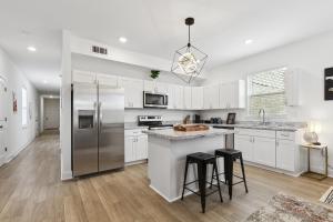a kitchen with white cabinets and a stainless steel refrigerator at New Luxury 3BR w Jacuzzi in New Orleans