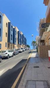 une rue avec des voitures garées sur le côté de la route dans l'établissement Los Abrigos Ocean relax, wifi, playas, à Los Abrigos