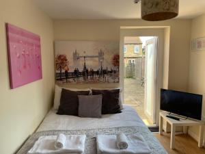 a bedroom with a bed and a tv and a window at Amazing Studio Room in Ilford! in Ilford