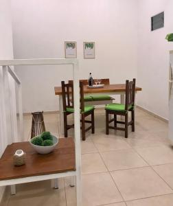 a dining room with a table and green chairs at Costanera in San Nicolás de los Arroyos