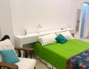 a bedroom with a green bed and a sink at Costanera in San Nicolás de los Arroyos