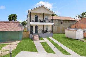 een huis met een tuin met groen gras bij Luxury 3br Oasis w Jacuzzi in New Orleans